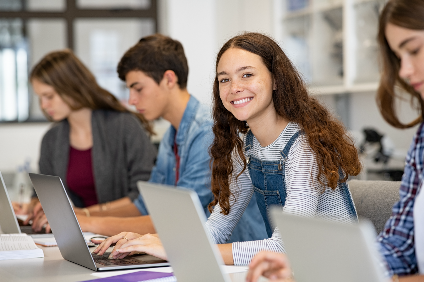 students with laptops in a classroom